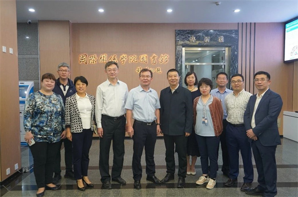 幸明军书记、许可副院长与各部门负责人在赵朴初先生题写的馆名前合影